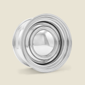 A polished chrome metal wheel rim with a multi-spoke design, shown on a solid light beige background.
